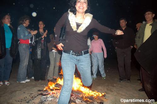 A Nowruz celebrant jumps over fire.