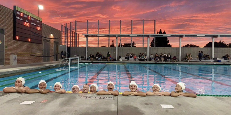 The water polo team celebrates a respetable game with the beautiful sunset. Courtesy of Sophia Baumann ‘23