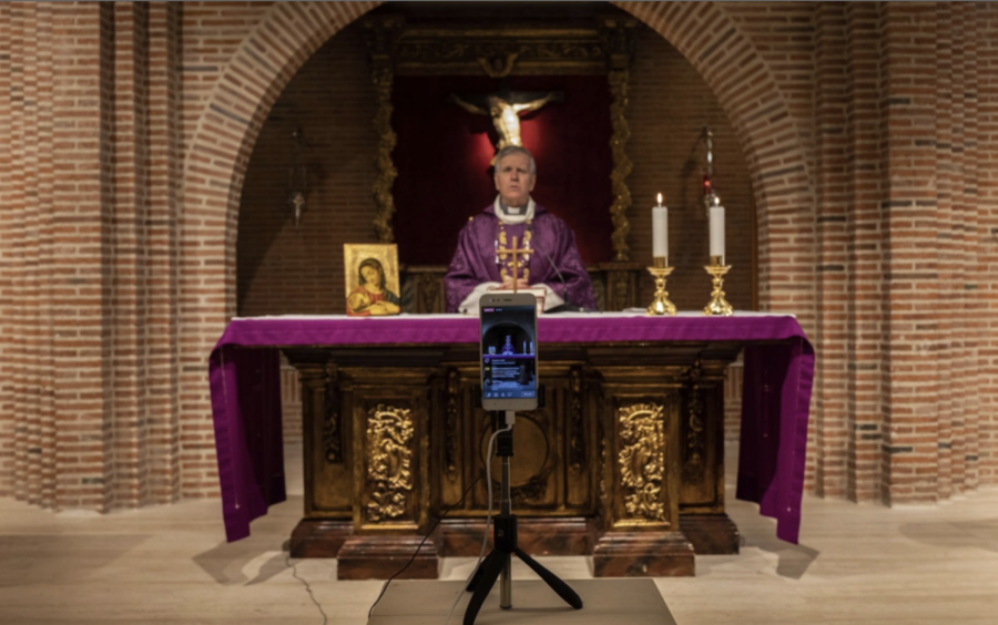 March 2020: A priest livestreams his mass in Madrid, Spain. Citizens are unable to attend daily mass and therefore, resulting in the reliance of the media. 