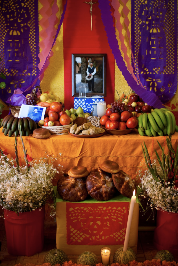 This is an ofrenda, which is often used to commemorate the lives of the deceased. The altar is decorated with delicacies that the deceased loved, flowers that represent the Earth they once walked on, candles that represent the element of fire, and colorful draperies to assist the deceased on their journey back to the Earth.