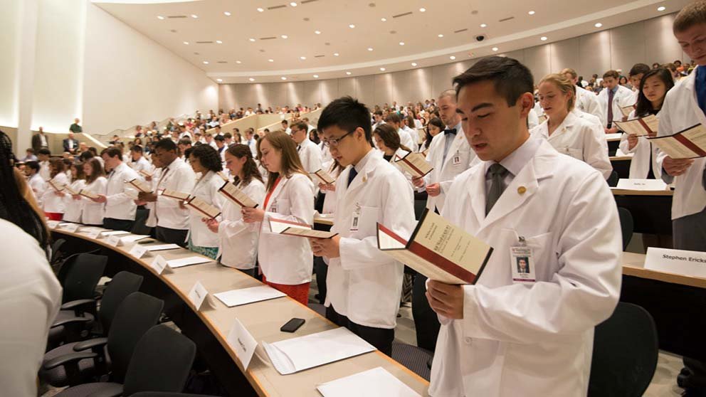 WUSM students read their Hippocratic Oath at a 2014 white coat ceremony via AAMC.org