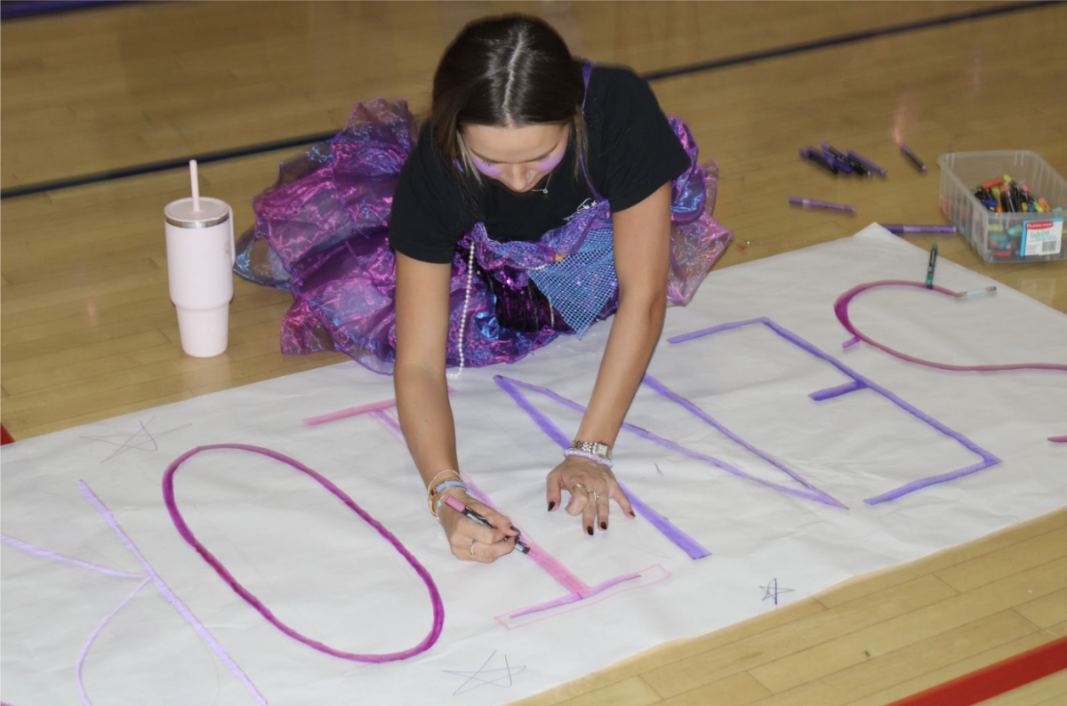 Senior making poster to help decorate Pavilion for Class Color Day! Taken by Caroline Crane
